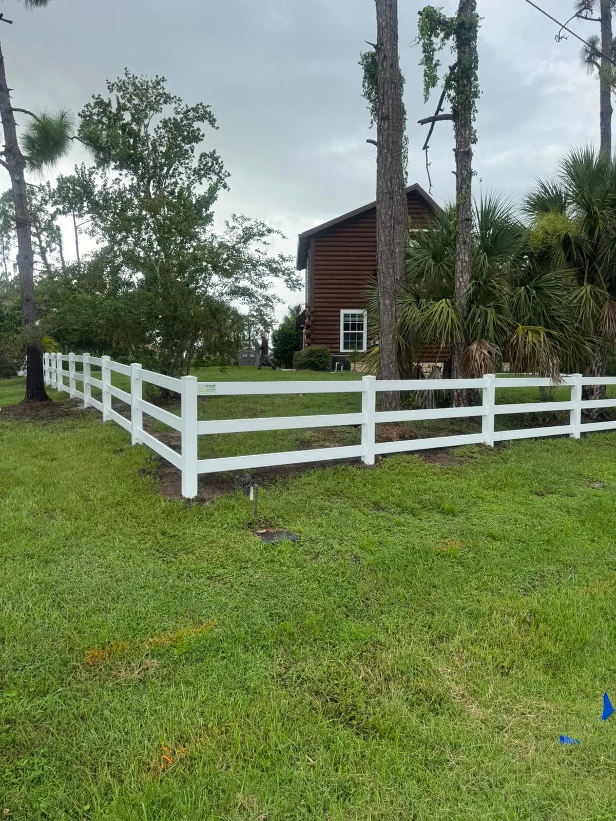 White vinyl ranch-style fence installed along a Southwest Florida property